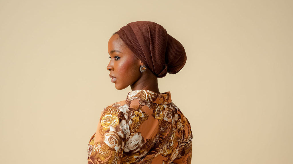 Woman wearing a patterned dress with a plain background